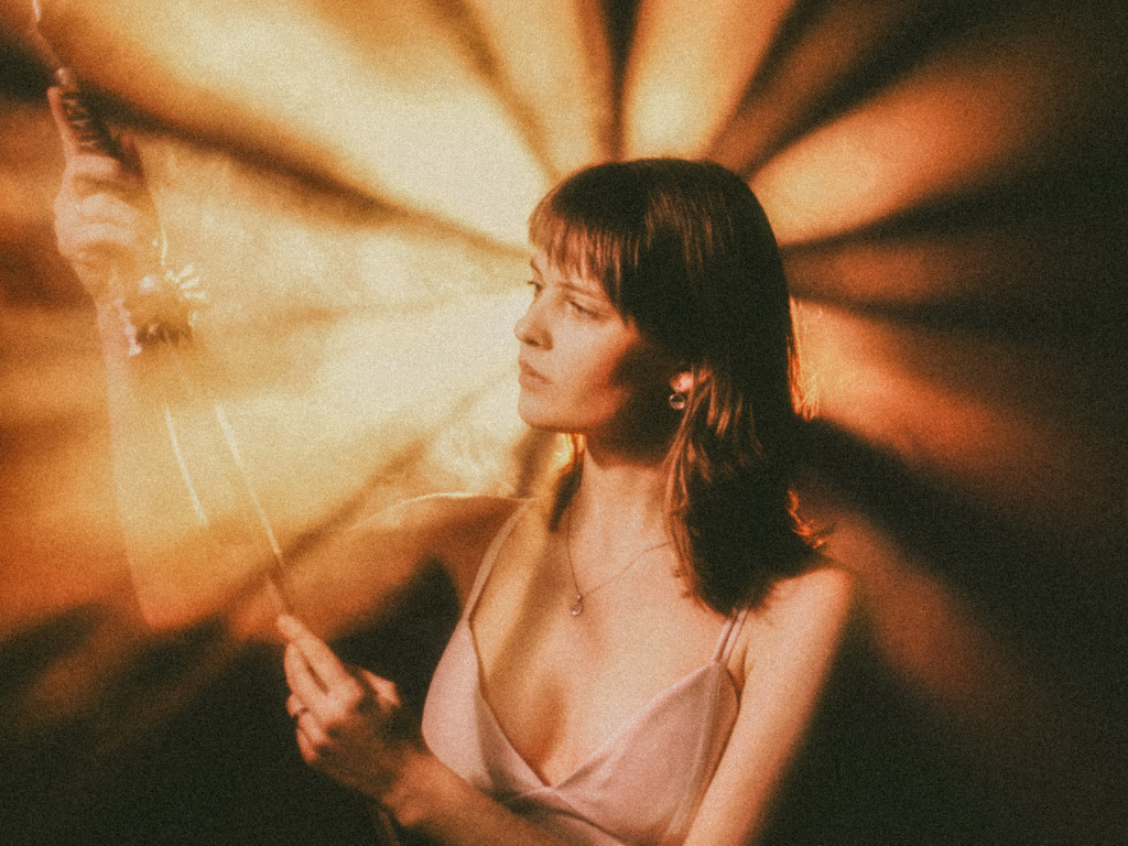 Eine Frau, die von einem Licht im Hintergrund angeleuchtet wird.